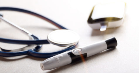 Personal blood glucose meter and lancet with stethoscope on the