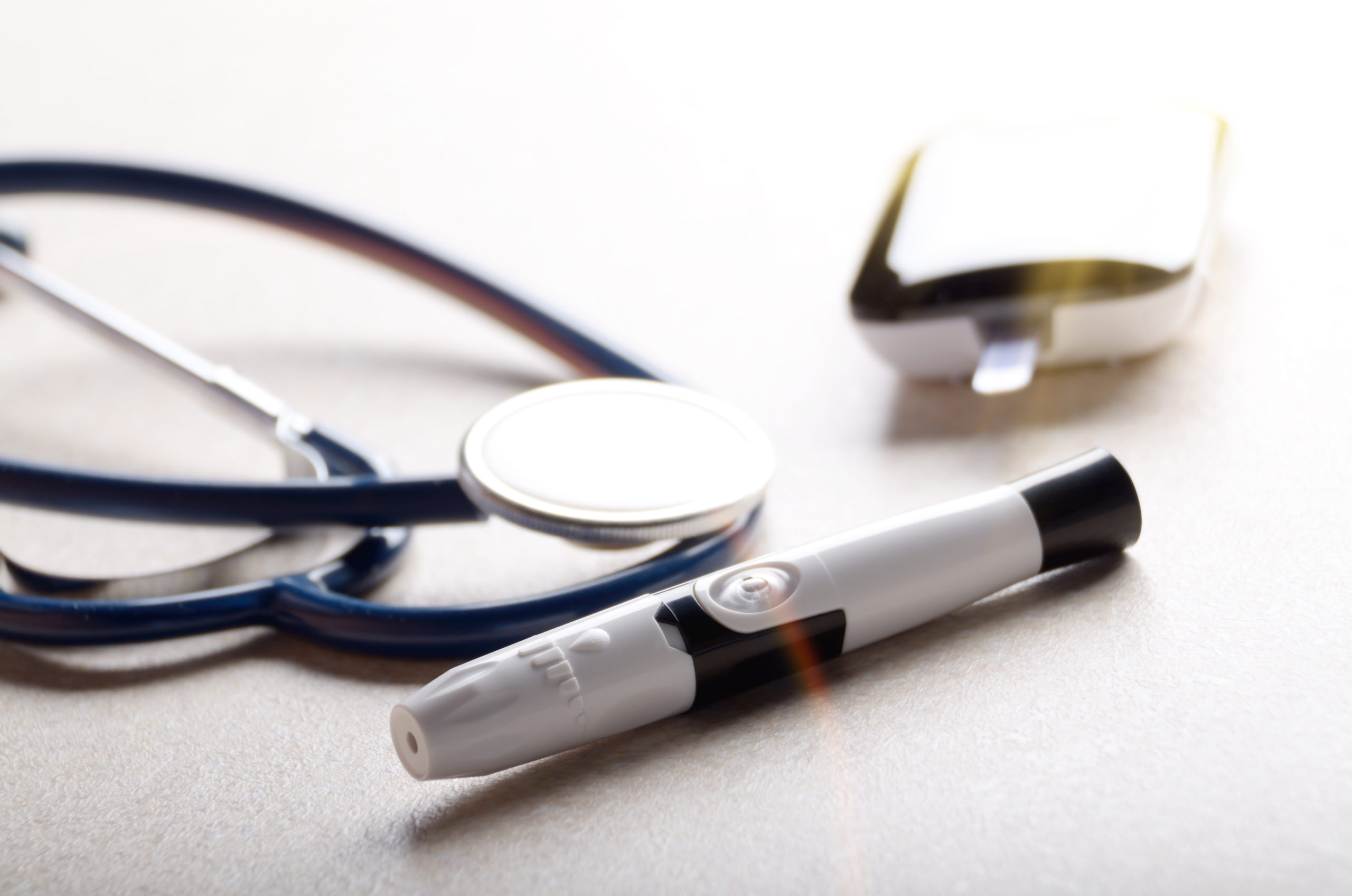 Personal blood glucose meter and lancet with stethoscope on the